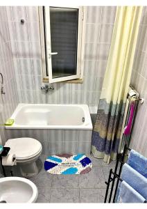 a bathroom with a tub and a toilet and a sink at Grace's Blue corner in Marconia +19 photos