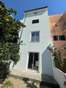 a white house with a window and two buildings at Orange tree apartment in Amarante