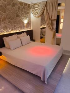 a bedroom with a large white bed with lights on it at GLS Priamos in Piraeus +10 photos