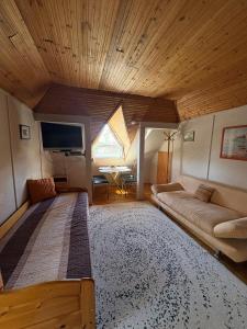 a large room with a large bed and a couch at Vank Apartman Barcs in Barcs