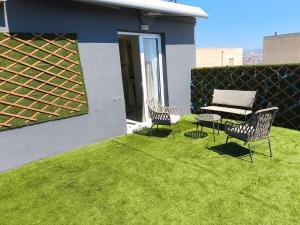 a patio with two chairs and a table on grass at GLS Priamos in Piraeus