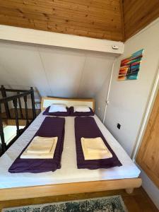 a large bed in a small room with wooden ceilings at Vank Apartman Barcs in Barcs