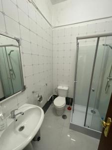 a bathroom with a toilet and a sink and a shower at Orange tree apartment in Amarante