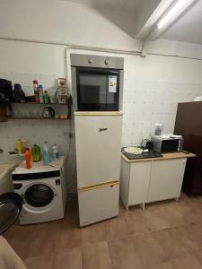 a small kitchen with a stove and a microwave at Orange tree apartment in Amarante