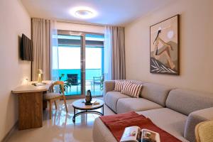 a living room with a couch and a table at Zeus Piraeus Grand in Piraeus