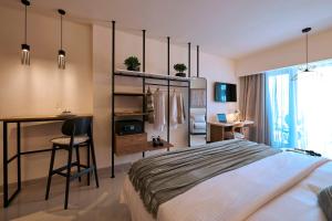a bedroom with a bed and a desk and a table at Zeus Piraeus Grand in Piraeus +73 photos