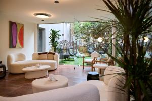 a living room with couches and tables and chairs at Zeus Piraeus Grand in Piraeus