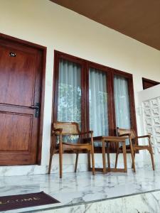 two chairs and a table in front of a door at Relaxing Homestay & Hostel in Kuta Lombok