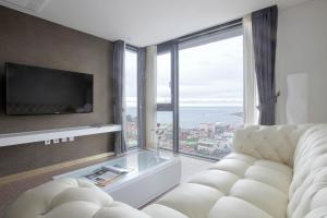 sala de estar con sofá y ventana grande en Eins Hotel en Seogwipo