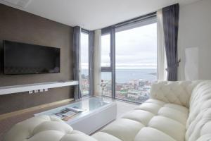 a living room with a couch and a large window at Eins Hotel in Seogwipo