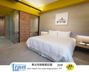 a bedroom with a large white bed in a room at Thinker Hotel in Yingge +5 photos