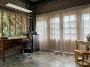 an office with a desk and a chair and windows at Quiet Page CNX in Ban Phae Buak Ha