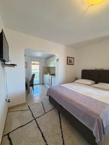 a bedroom with a large bed and a kitchen at Apartmani Anđelo, Tommy, Leon in Bibinje