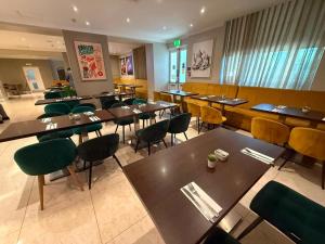 a restaurant with tables and chairs in a room at Park Avenue Bayswater Inn Hyde Park in London