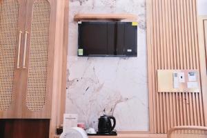 a kitchen with a tv on a wall at Thong Dong homestay&villas in Ninh Binh