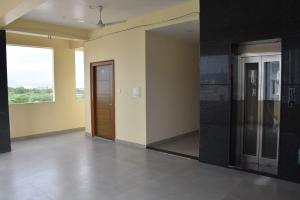 an empty room with a door and a window at PVR Grand in Tirupati