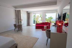 a bedroom with a red couch and a living room at Novaeos Sicily in Terrasini