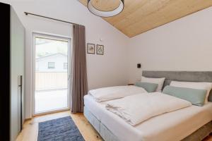 a bedroom with a large white bed and a window at Gratzenthal Boutique Apartments in Hollenstein an der Ybbs