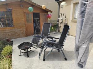 three chairs and a grill in front of a house at Séjour près de Bayeux avec Massages et repas en options in Tilly-sur-Seulles