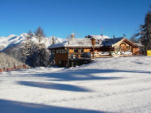 a log cabin with snow on top of it at Chalet Degli Angeli in Folgarida
