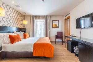 a hotel room with a bed and a flat screen tv at Vila Sao Vicente Boutique (Adults Only) in Albufeira