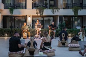 a group of people sitting in a circle in front of a building at Planos Deluxe in Zakynthos