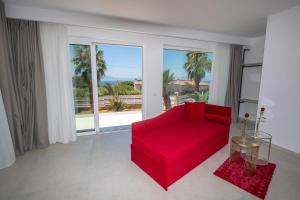 a living room with a red couch and a large window at Novaeos Sicily in Terrasini +114 photos