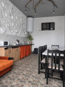 a kitchen with a table and chairs and a kitchen with a counter at Хостел Арабея in Vinnytsya +13 photos