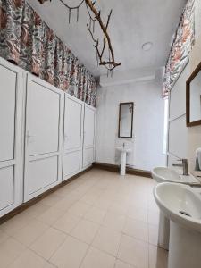 a bathroom with white cabinets and a sink and a mirror at Хостел Арабея in Vinnytsya
