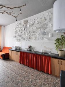 a kitchen with a counter with plates on the wall at Хостел Арабея in Vinnytsya