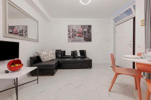 a living room with a black couch and a table at Casa Sole Porlezza in Porlezza