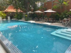 a large blue swimming pool with chairs and umbrellas at Suite Home Boutique Hotel in Phnom Penh