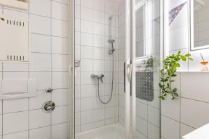 a bathroom with a shower with white tiles at bleib. Boutique Fewos Bodensee in Radolfzell am Bodensee +62 photos