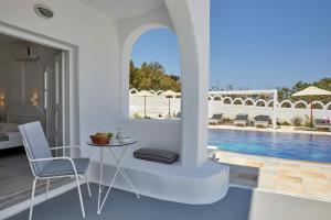 a living room with a table and chairs and a pool at Santorini View in Akrotiri +58 photos