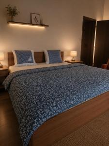 a bedroom with a large bed with blue sheets and pillows at Hotel Bellevue in Doksy