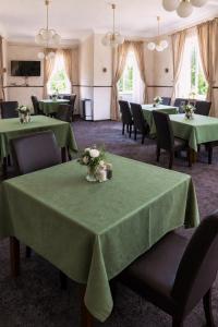 a dining room with green tables and chairs at Hotel Bellevue in Doksy +13 photos
