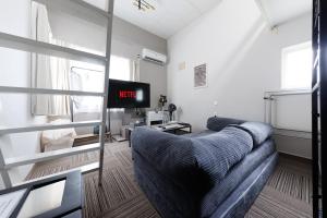 a living room with a couch and a tv at Gran Form Kita 12-jo in Kita-sanjō