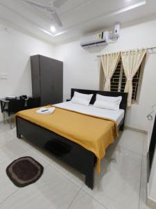 a bedroom with a bed with a yellow blanket on it at Hotel 7 dreamers in Vākalapūdi