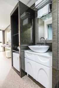 a bathroom with a sink and a mirror at Eins Hotel in Seogwipo