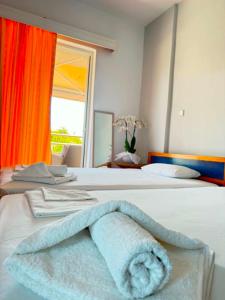 a room with two beds with a towel on it at Hotel Fotini in Mytikas +56 photos