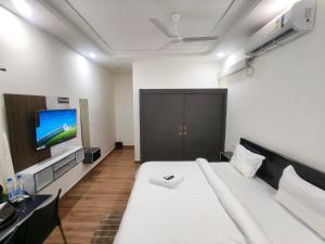 a bedroom with a white bed and a flat screen tv at Hotel 7 dreamers in Vākalapūdi