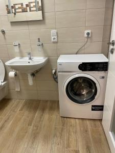 a bathroom with a washing machine and a sink at Penzion Netolice in Netolice +118 photos