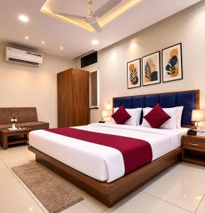 a bedroom with a large bed with red pillows at Accuotel Hotel Perfect in Indore