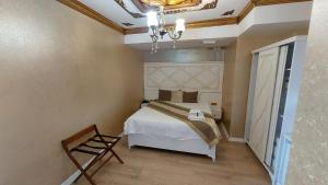 a bedroom with a bed and a chandelier at Aksu Otel in Aliağa
