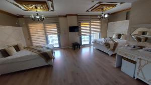a large room with two beds and a television at Aksu Otel in Aliağa