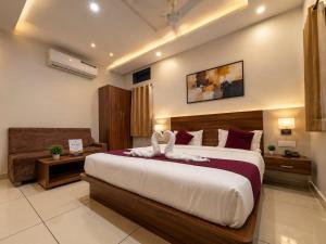 a bedroom with a large bed and a couch at Accuotel Hotel Perfect in Indore +8 photos