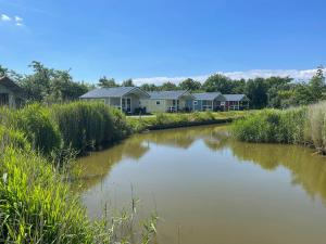 a river with a row of houses in the background at Waddenlodge Exclusive in Harlingen