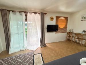 a living room with a television and a table with chairs at ดูดาวแคมป์ริมโขง in Chiang Khan +37 photos