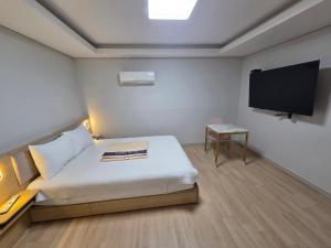 a bedroom with a bed and a flat screen tv at 센스모텔 in Sasang-yŏk +30 photos