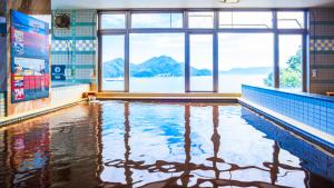 a swimming pool with a view of the mountains at Livemax Resort Mihara Onsen Seafront in Mihara